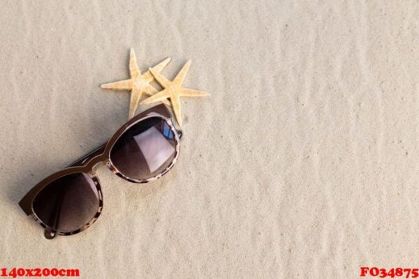 heap of shells and sunglasses lying on sand