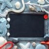 blank blackboard with sea shells, stones, rope and star fish on