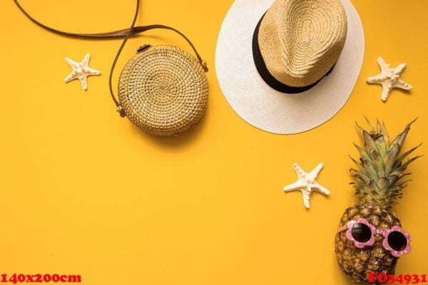 colorful summer female fashion outfit flat lay. straw hat, bamboo bag, pineapple in sunglasses and starfish over yellow background, top view. summer fashion, holiday concept.