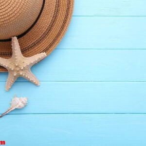 beach hat with seashells on blue wooden table