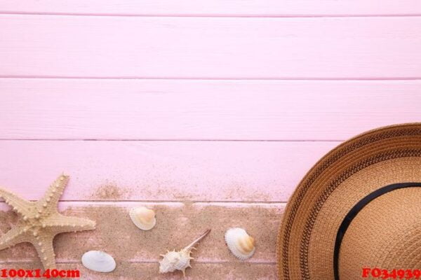 beach hat with seashells on pink wooden table