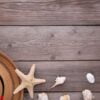 beach hat with seashells on grey wooden table