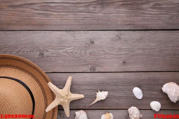 beach hat with seashells on grey wooden table