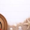 beach hat with seashells on white wooden table