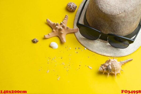 summer accessories, shells, hat and sun glasses on yellow backgr