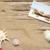 sand and book on planked wood. summer background with copy space