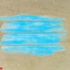 top view of beach sand with blue wooden background.