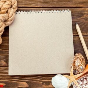 shells and notepad on wooden table. top view with copy space