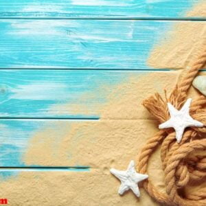 sea rope with many different sea shells on the sea sand on a blue wooden background. top view