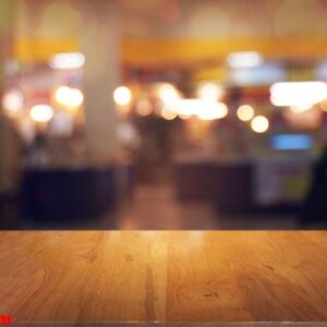 empty wooden table in front of abstract blurred background of co