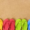 flip flops in a row on a sandy beach. space for copy.