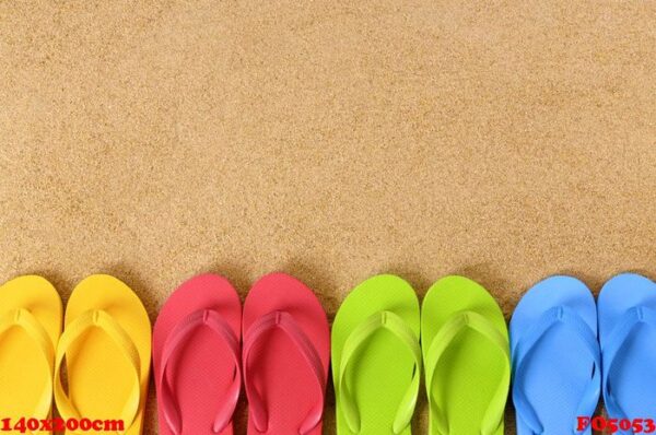 flip flops in a row on a sandy beach. space for copy.