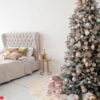 decorated christmas tree in room with bed.