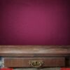 empty wooden table against a violet wall.