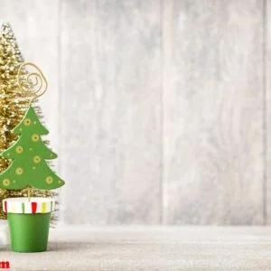 artificial christmas tree on a wooden background.