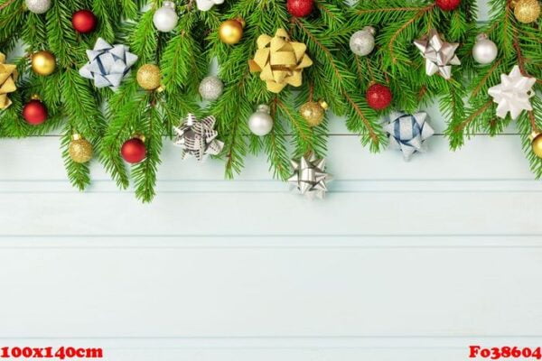 christmas composition, christmas tree branches decorated with small balls and gold and silver bows. copy space on a light blue plank background.