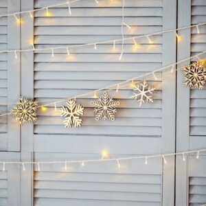 christmas decoration on the wall. wooden christmas garland and lanterns.