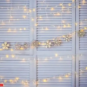 christmas decoration on the wall. wooden christmas garland and lanterns.