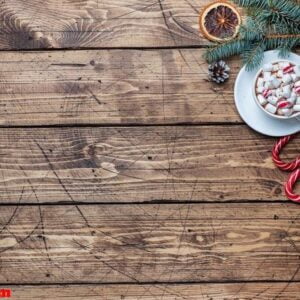 a cup of hot chocolate with marshmallows. christmas tree and decorations, cane caramel and oranges nuts wooden background copy space.