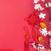 design concept of chinese lunar new year beautiful chinese knot with plum blossom isolated on red background, flat lay, top view, overhead layout.