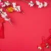 design concept of chinese lunar new year beautiful chinese knot with plum blossom isolated on red background, flat lay, top view, overhead layout.