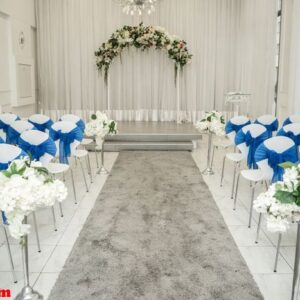 bright room for weddings. rows of guest chairs decorated with blue cloth