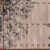 brown wall from wooden planks between two brick pillars