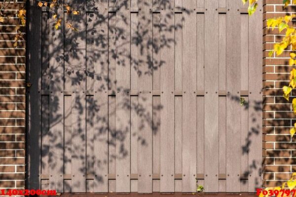 brown wall from wooden planks between two brick pillars