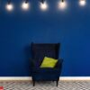 dark blue arm chair against blue wall in modern living room