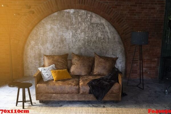 modern luxury interior of a room or living room with a brick wall and a stylish velour brown sofa and designer pillows. next to it is an elegant lamp. hotel room.