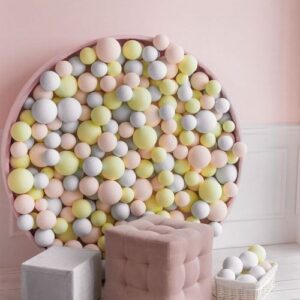 photo zone with pouf and colorful balls on wall.