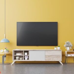 tv on cabinet in modern living room with lamp,table,flower and plant on yellow wall background.