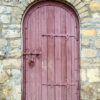 ancient wooden door in old stone wall.