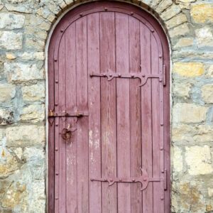 ancient wooden door in old stone wall.