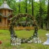 arch for a wedding ceremony in a pine forest. church. candles in decorated jars. newlyweds. wedding decorations.