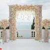 elegant wedding arch with fresh flowers, vases on background of