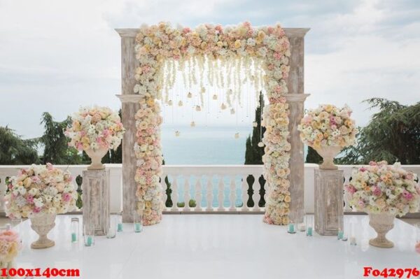 elegant wedding arch with fresh flowers, vases on background of