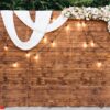 rustic wooden wedding arch with retro garland decorated with flowers for wedding ceremony newlyweds