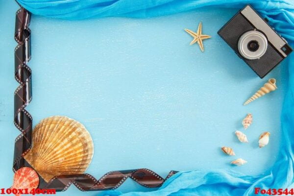 blank paper photo frame with starfish, shells and items on wooden table.