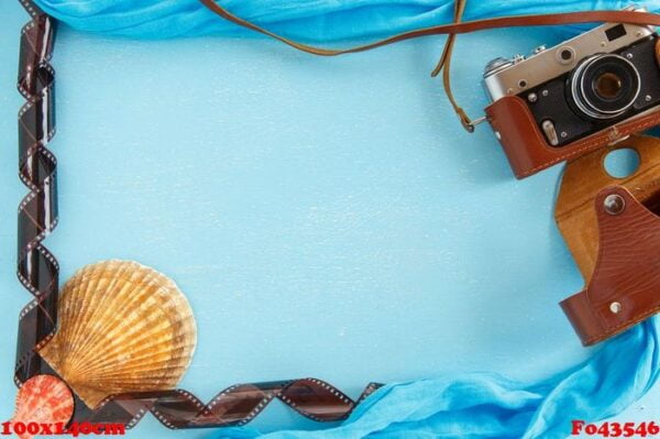 blank paper photo frame with starfish, shells and items on wooden table.