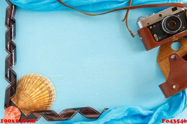 blank paper photo frame with starfish, shells and items on wooden table.