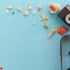 blank paper photo frames with starfish, shells and items on wooden table.