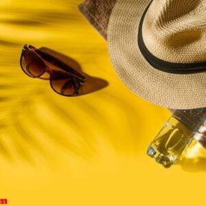 hat and glasses on bright yellow background with bottle of water