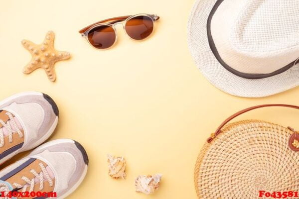 stylish rattan bag, monstera branches, sunglasses, sneakers, hat on yellow background. top view with copy space. trendy bamboo bag. summer fashion flat lay