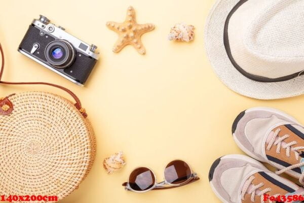 summer vacation background. sneakers, rattan bag, sunglasses, hat and retro camera on a yellow background. flat lay. copy space