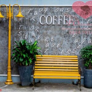 bright yellow bench and lamp post and flower pots with plants against a gray concrete wall on a street in da nang, vietnam