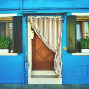 front of the blue house on the island of burano. italy, venice. toned