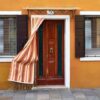 front of the yellow house on the island of burano. venice, italy