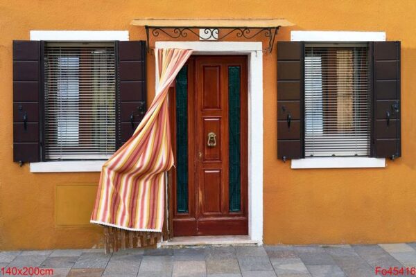 front of the yellow house on the island of burano. venice, italy