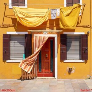 front of the yellow house on the island of burano. venice, italy